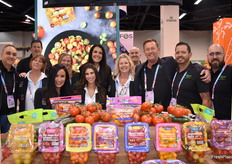 Team Village Farms poseert trots bij een kleurrijke tentoonstelling van in de kas geteelde tomaten.