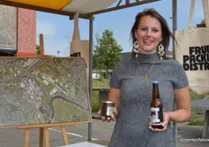 Marjolein Smits van Oyen met de mandarijnenradler, compost uit het bierverwerkingsproces en op de achtergrond de kaart met rood omlijnd de toekomstige woonwijk.