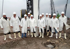 Burgemeester Van der Tak en de aandeelhouders poseren bij de duizendste paal voor de nieuwbouw van GreenPack, vlak voordat deze wordt geslagen.