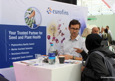 Davide Censi (Eurofins) staat een beursbezoeker te woord.