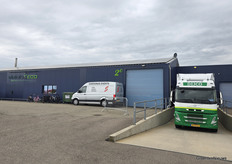 Vrachtwagen aan het dock, bezoekers binnen in de kas en schuur bij Viridis-Eco