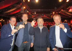 Xander van der Wilk, Jeroen Heemskerk, Michel Le Coz en Cees van Uffelen proosten met op de achtergrond een bomvolle zaal.